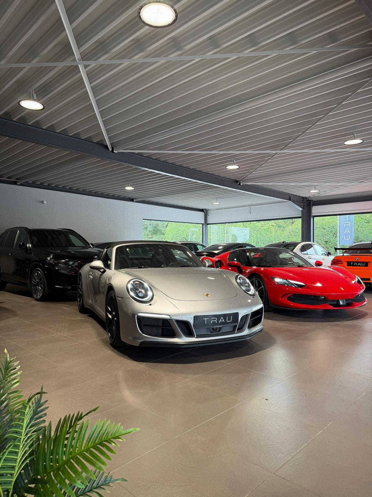 Ausstellungshalle der TRAU GmbH mit Porsche und Ferrari